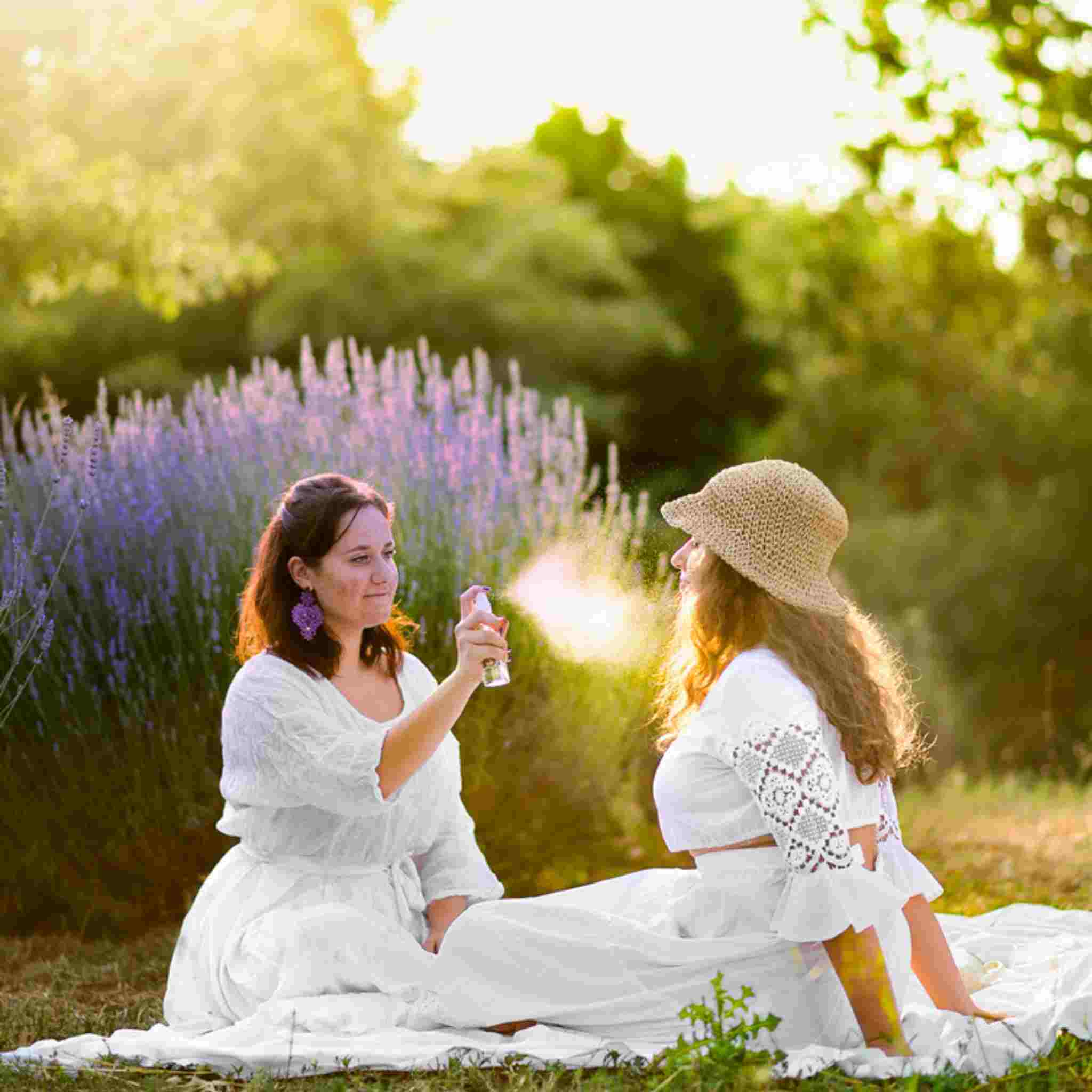 Ragazza spruzza idrolato di lavanda bio nel campo di lavanda biologica Podere Argo