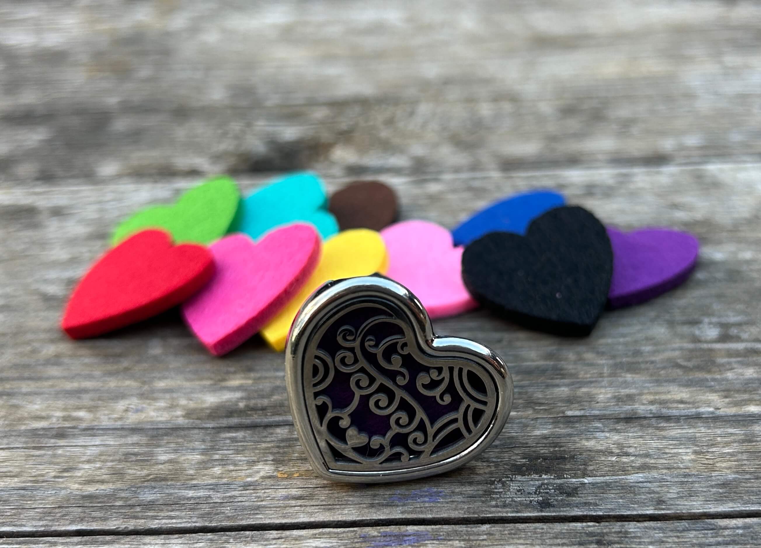 Dettaglio del profumatore auto a cuore con tamponi ricambio colorati texture naturale e finitura metallica